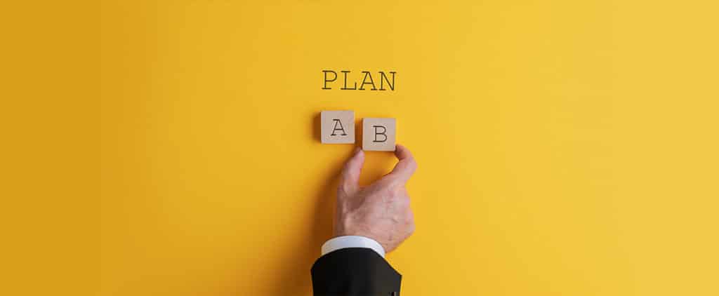 Hand placing wooden blocks for Plan A and Plan B