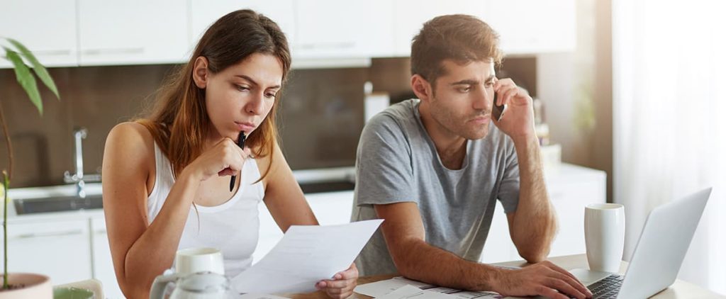 Couple sitting at cable going through bills