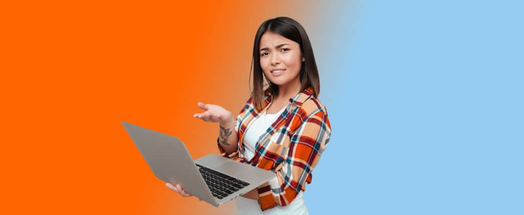 Woman holding laptop with confused look on her face
