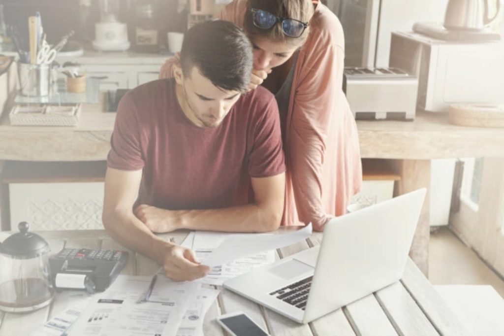 Couple sitting at a kitchen table looking at documents